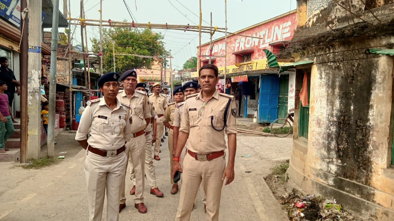 फ्लैग मार्च करते हुए पुलिसकर्मी व पदाधिकारी